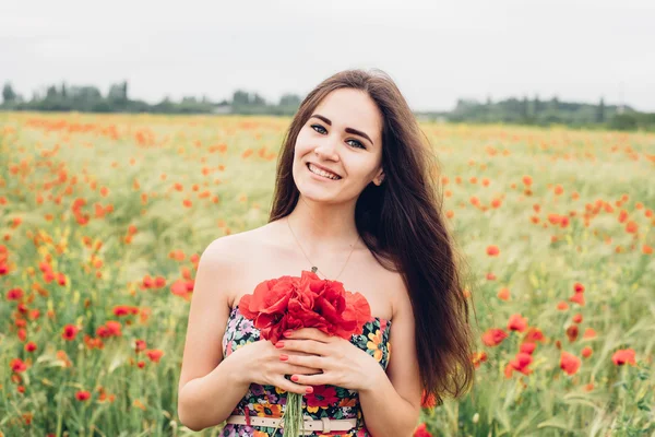 Mujer joven en el campo de amapola —  Fotos de Stock