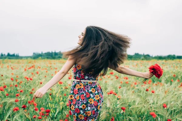 Young woman in poppy field — Stock Photo, Image