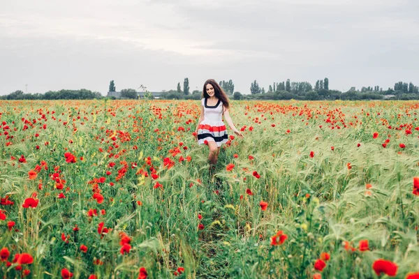 Young woman in poppy field — Stock Photo, Image