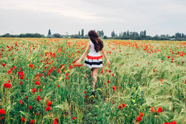 Jovem mulher no campo de papoula — Fotografia de Stock