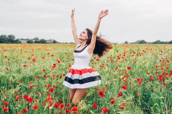 Young woman in poppy field — Stock Photo, Image