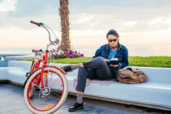 Mujer con bicicleta descansando en la orilla del mar — Foto de Stock