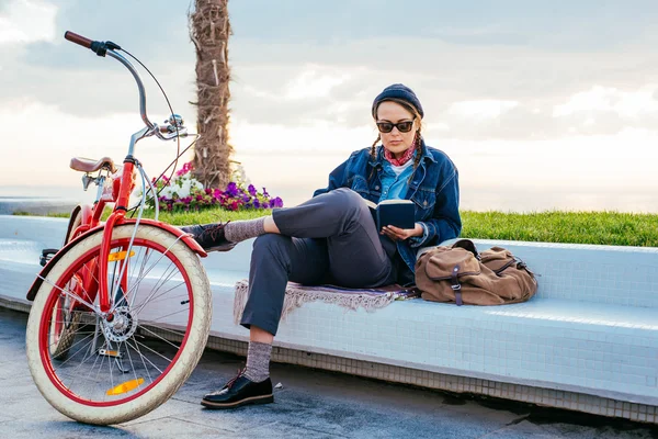 Mujer con bicicleta descansando en la orilla del mar — Foto de Stock