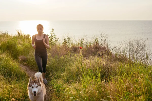 Kobieta i husky jogging w parku — Zdjęcie stockowe