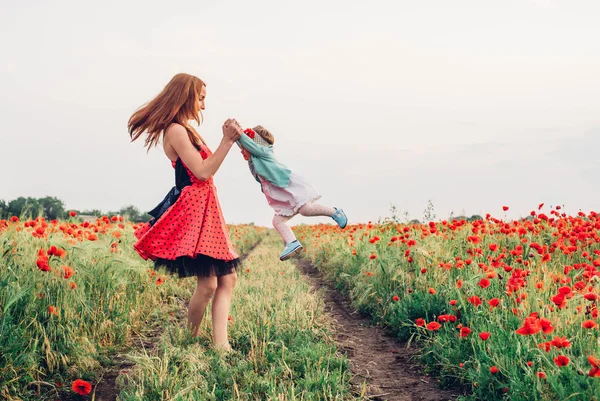 Madre e hija en el campo de amapola — Foto de Stock