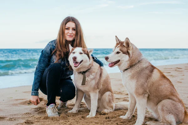 Kobieta i husky na plaży — Zdjęcie stockowe