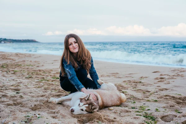 Kobieta i husky na plaży — Zdjęcie stockowe