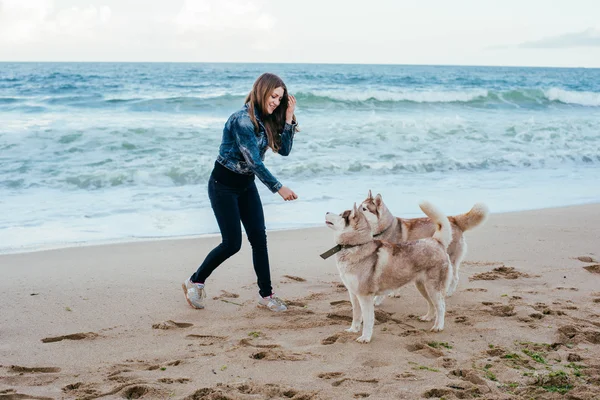 Mulher e husky na praia — Fotografia de Stock