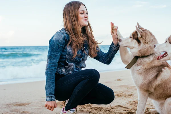 Kobieta i husky na plaży — Zdjęcie stockowe