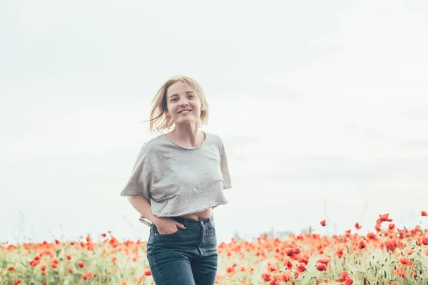 Mujer joven en el campo de amapola —  Fotos de Stock