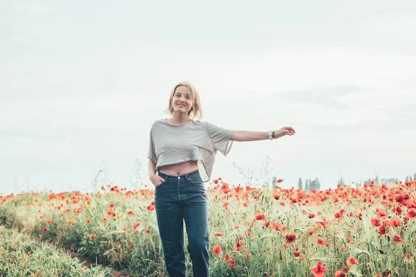 Mujer joven en el campo de amapola —  Fotos de Stock