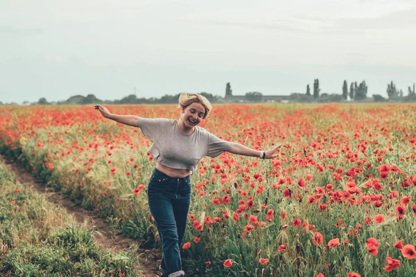 Mujer joven en el campo de amapola —  Fotos de Stock