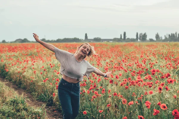 Young woman in poppy field — Stock Photo, Image