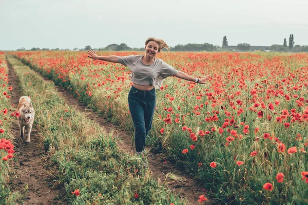 Young woman in poppy field — Stock Photo, Image