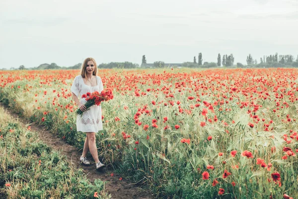 Young woman in poppy field — Stock Photo, Image