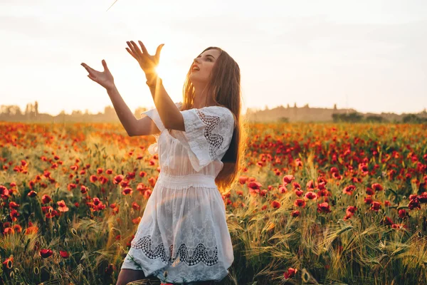 Mladá žena v makovém poli — Stock fotografie