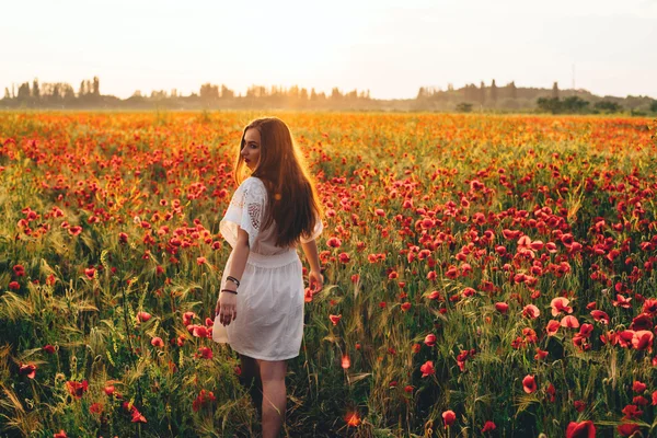 Mladá žena v makovém poli — Stock fotografie