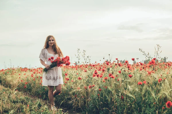 Mladá žena v makovém poli — Stock fotografie