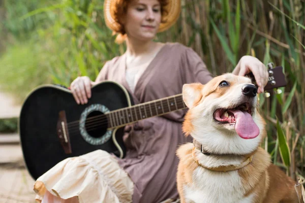 Kvinna med gitarr och hund — Stockfoto