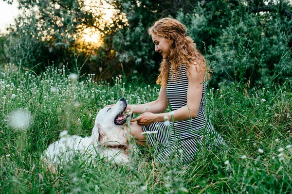 Meisje met hond in het park spelen — Stockfoto
