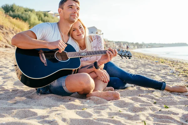 happy couple playing guitar