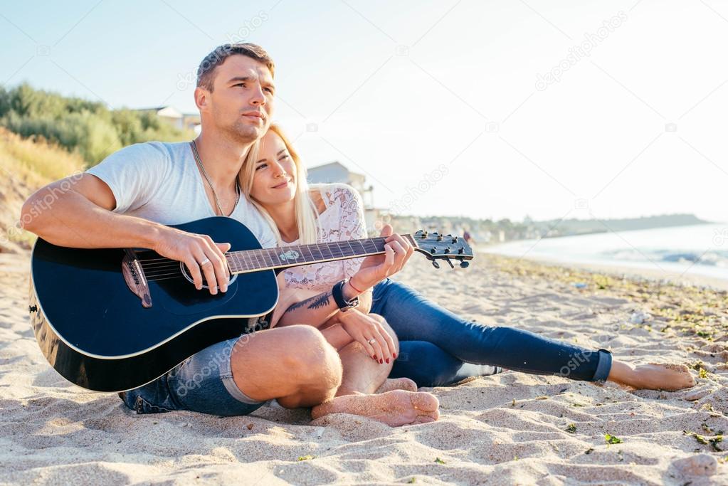 happy couple playing guitar 