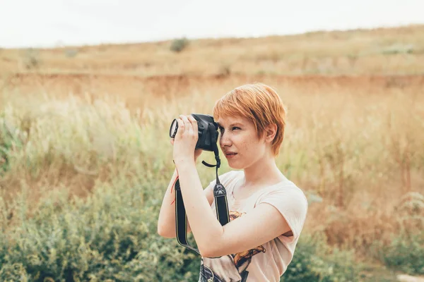 Mulher ruiva fotógrafo tirar fotos ao ar livre — Fotografia de Stock