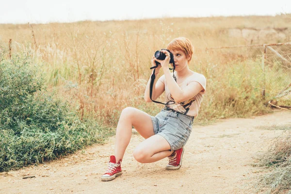Рыжая женщина-фотограф — стоковое фото