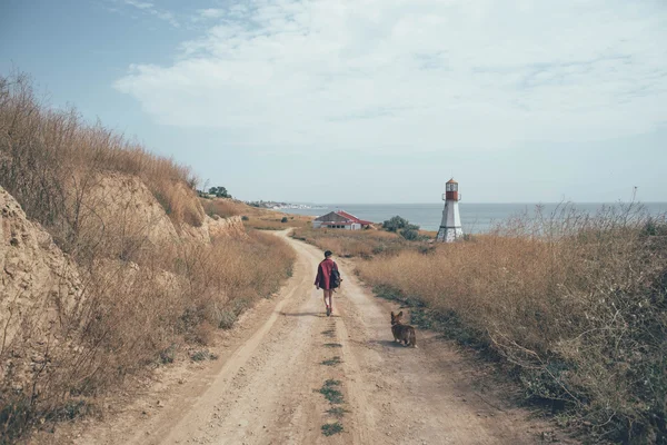 Pelirroja chica con galés corgi perro en la playa Imágenes De Stock Sin Royalties Gratis