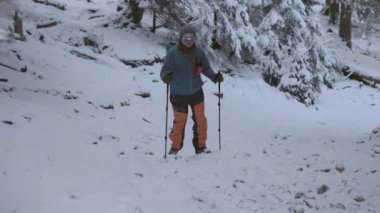 Kış mevsiminde insanların karlı ve soğuk dağlarda yürüyüş yaparken 4k yavaş çekim