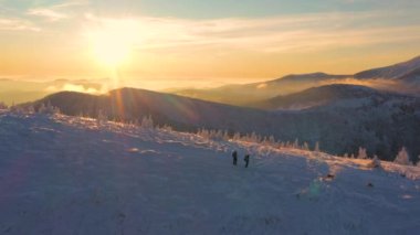 Yürüyüşçülerin güzel karlı dağlardaki hava görüntüleri. Uzak yerlere seyahat kavramı