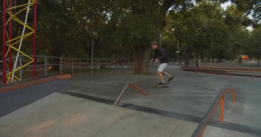 ... kaykaycı ve kaykaycısıyla kaykay yaparken 4k ağır çekim kaydırağını açık havada kaykaycı parkında yapıyor.