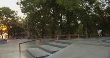 ... kaykaycı ve kaykaycısıyla kaykay yaparken 4k ağır çekim kaydırağını açık havada kaykaycı parkında yapıyor.