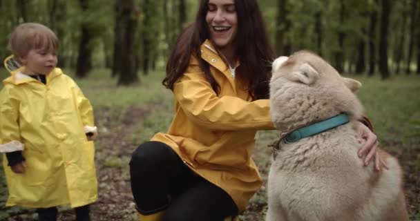 Familie Gele Regenjassen Spelen Met Schattige Siberische Husky Het Herfstbos — Stockvideo