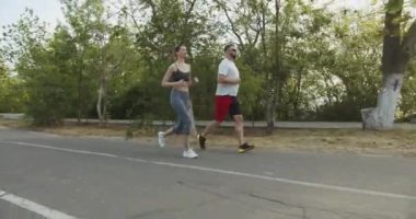 Beyaz erkek ve özel antrenörü genç bayan sporcu sabah dışarı koşuyor. Sağlıklı aktif yaşam tarzı kavramı.