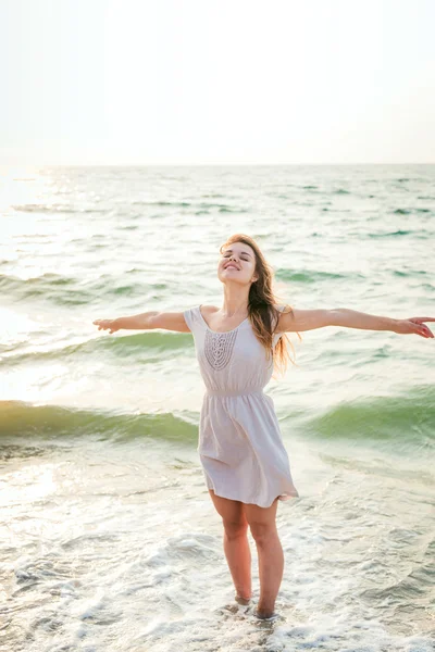 Joven hermosa hembra caucásica disfrutando del sol en la playa al amanecer o al atardecer — Foto de Stock