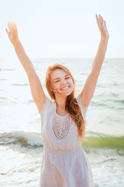 Joven hermosa hembra caucásica disfrutando del sol en la playa al amanecer o al atardecer — Foto de Stock