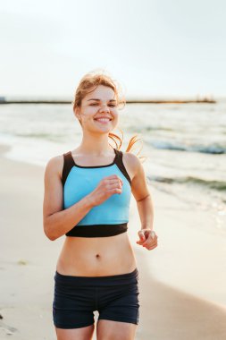 Çalışan kadın. Kadın atlet gündoğumu sırasında sahilde koşu.
