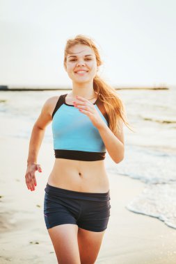 Çalışan kadın. Kadın atlet gündoğumu sırasında sahilde koşu.