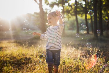 küçük kız balonu üfleyici parkta oynamak