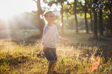küçük kız balonu üfleyici parkta oynamak