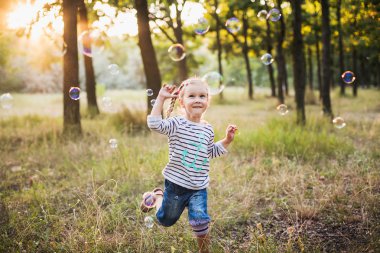 küçük kız balonu üfleyici parkta oynamak