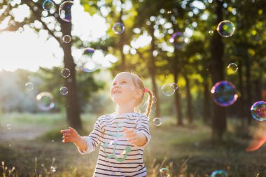 küçük kız balonu üfleyici parkta oynamak