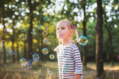 küçük kız balonu üfleyici parkta oynamak