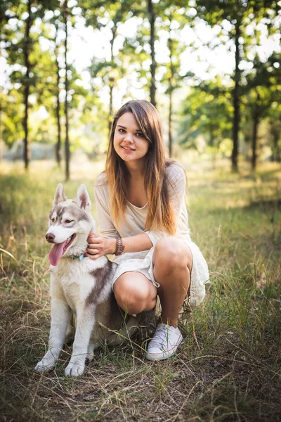 Młody kaukaski kobieta z siberian husky szczeniaka w parku — Zdjęcie stockowe