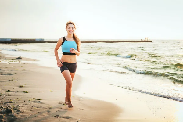 Běžící žena. Běžkyně běhání během východu slunce na pláži. — Stock fotografie
