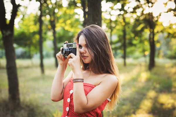 Unga kaukasiska kvinna med vintage kamera i park — Stockfoto