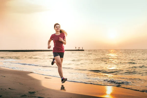 女性を実行します。ビーチで日の出の時ジョギング女性ランナー. — ストック写真