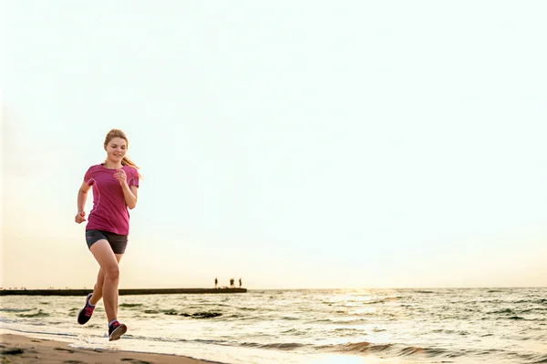 女性を実行します。ビーチで日の出の時ジョギング女性ランナー. — ストック写真