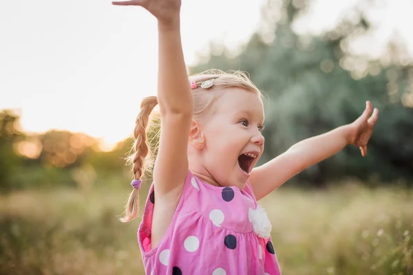 Liten flicka som leker i parken i sommardag under solnedgången — Stockfoto